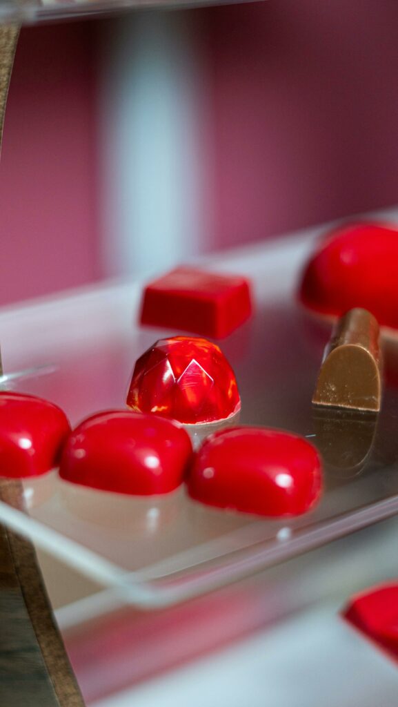 Close-up of vibrant red confectionery pieces arranged elegantly on a display.
