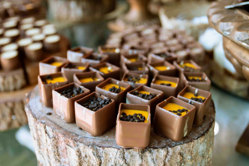 A close-up of decorative chocolate cubes with rich toppings displayed on a rustic wooden surface in Brazil.