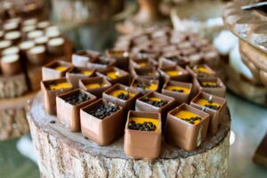 A close-up of decorative chocolate cubes with rich toppings displayed on a rustic wooden surface in Brazil.